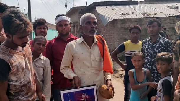 Akhileshwar Pandey, head of Durga puja samiti in Harkhadi village (holding the portrait). On his right is Suraj Pandey