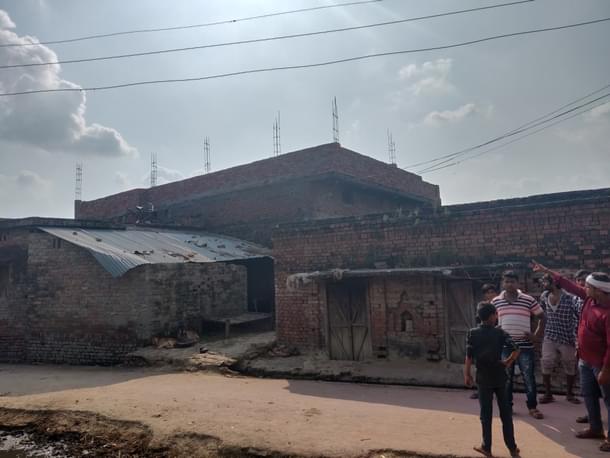 Suraj Pandey (in red) and others point at a terrace from where stones were pelted