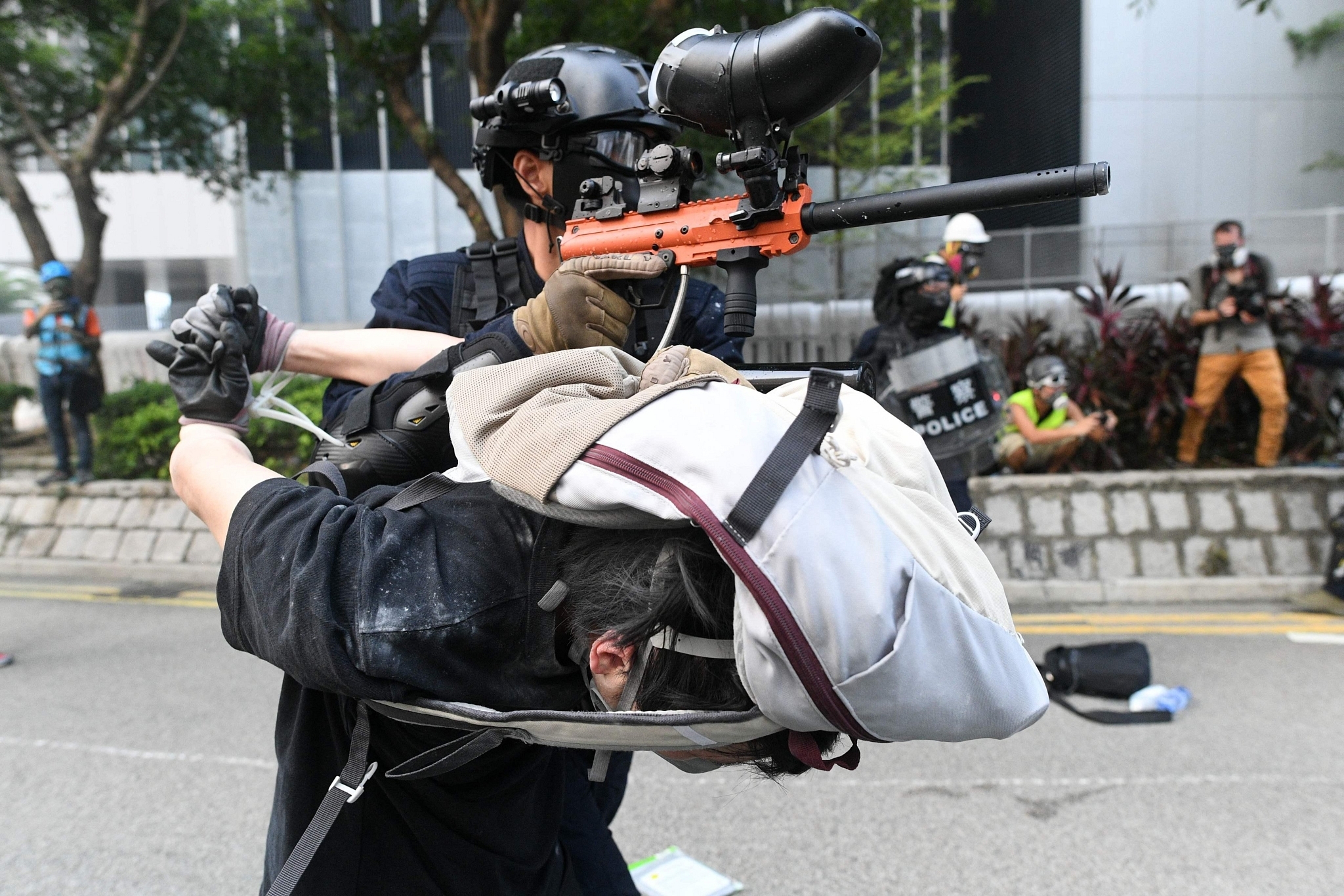 Hong Kong Police using subdued protester as gun mount.(via Twitter)