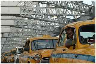 Kolkata taxi drivers in their out-dated cars on Howrah Bridge in Kolkata (DIBYANGSHU SARKAR/AFP/Getty Images)
