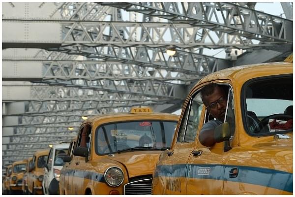 Kolkata taxi drivers in their out-dated cars on Howrah Bridge in Kolkata (DIBYANGSHU SARKAR/AFP/Getty Images)