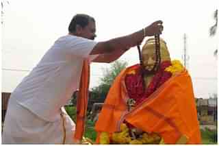 Arjun Sampath garlanding Thiruvalluvar’s statue. (Twitter)&nbsp;