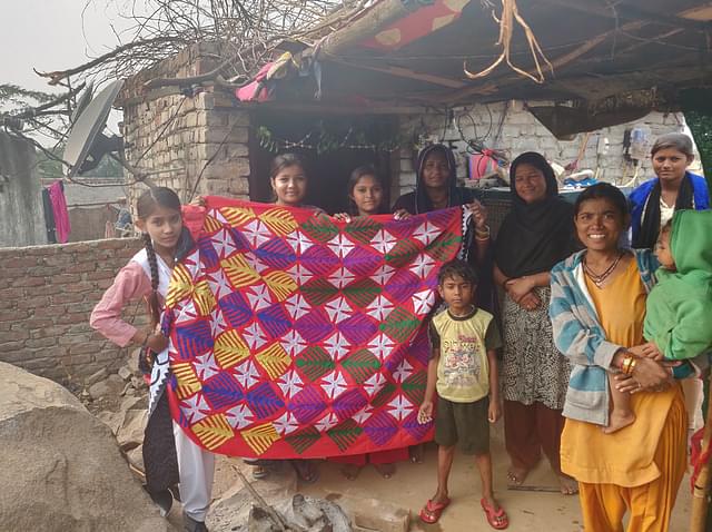 Kesro’s family shows a self-embroidered blanket.