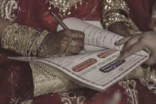 A woman signs a Nikah Nama -Representative Image (Photo by Kunal Patil/Hindustan Times via Getty Images) 