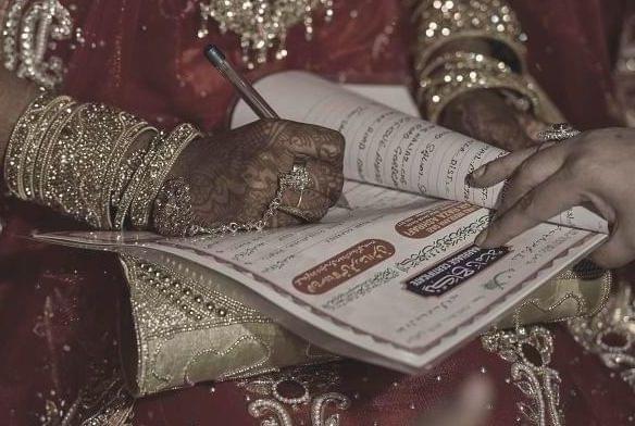 A woman signs a Nikah Nama -Representative Image (Photo by Kunal Patil/Hindustan Times via Getty Images) 