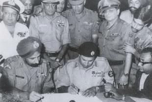 Lt Gen Niazi signing the Instrument of Surrender under the gaze of Lt Gen Aurora. (Indian Navy)