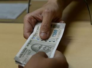 (Representative Image) A bank employee hands new Rs 500 rupee notes to a customer on 24 November  2016. Photo credit: INDRANIL MUKHERJEE/AFP/GettyImages