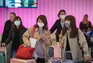 Passengers wear masks to protect against the spread of the coronavirus as they arrive at the Los Angeles International Airport, California. (Mark Ralston/AFP)