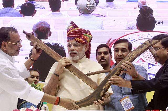  Prime Minister Narendra Modi being presented a model of plough by Agriculture Minister Radha Mohan Singh. (Photo by Sanjeev Verma/Hindustan Times via Getty Images)