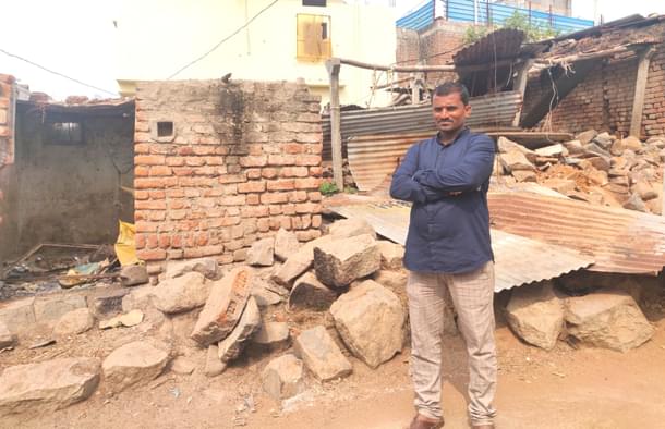 Raju from Korbagalli stands in front of his fire-ravaged house.