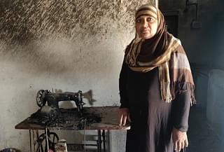 Afsari Begum With her burnt sewing machine.