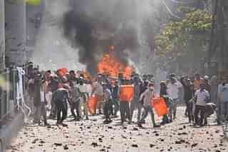 Protesters hurl stones during Delhi violence.