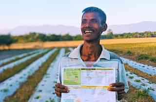A farmer with his soil health card. (NITI Aayog/Twitter)