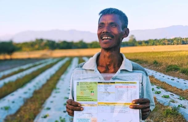 A farmer with his soil health card. (NITI Aayog/Twitter)