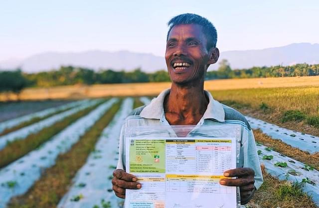 A farmer with his soil health card. (NITI Aayog/Twitter)
