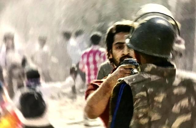 Mohammad Shahrukh, pointing a gun straight into the face of a policeman. He has now been detained (Source: @Soumyajit_Dutta/Twitter)