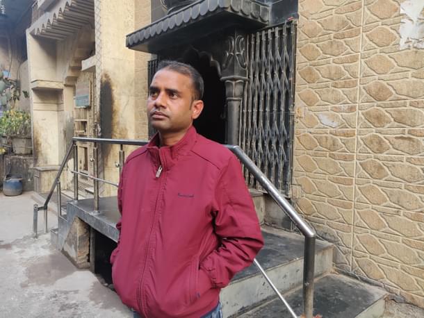 Bijendra Verma stands outside the temple. The house on the right of the temple belongs to him. 