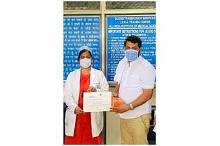 Azad accepting certificate of appreciation for blood donation at AIIMS
