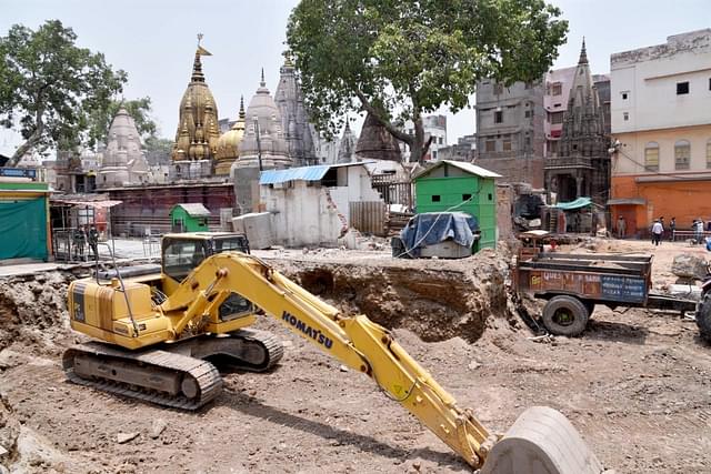 Demolition work on at the site with the Kashi Vishwanath temple in the background