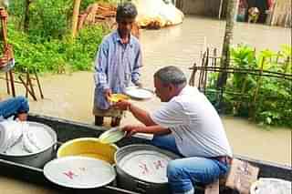 BJP legislator Mrinal Saikia helping flood victims.