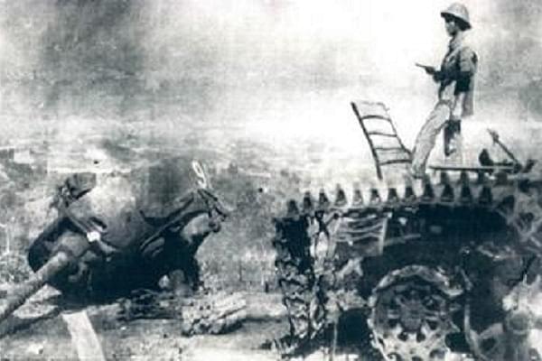Vietnamese officer standing on a destroyed Chinese tank (Wikimedia Commons)