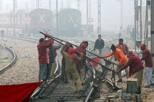 Indian Railways employees work on a railway track in New Delhi. (RAVEENDRAN/AFP/Getty Images)
