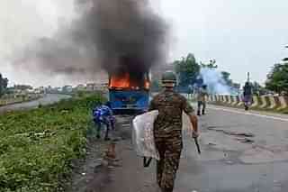Security personnel at the scene where angry mobs torched vehicles after the rape and murder of the 16-year-old girl.&nbsp;