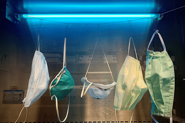 Surgical masks being decontaminated for reuse under ultraviolet light in a biosafety cabinet. (OKJaguar/Wikimedia Commons)