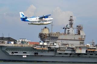 A Twin Otter 300 seaplane. IAC Vikrant can be seen in the background. (Twitter)