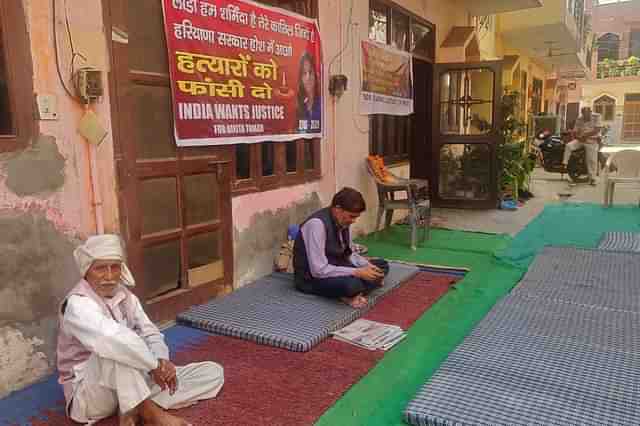 Nikita Tomar’s father Moolchand Tomar (in black) at his house after her murder on 26 October. (Swarajya)&nbsp;