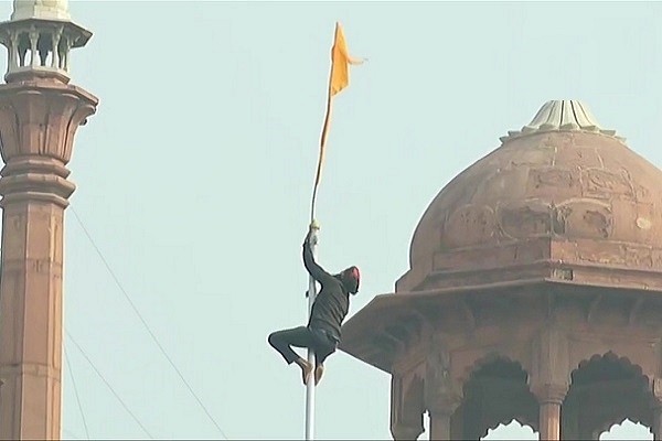 Violent farmer protester hoisting Sikh Flag at the red fort Source: @ANI/Twitter