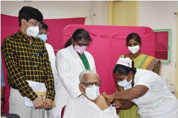 Dr Hande taking a  second dose of the Covid vaccine as Health Secretary Dr J Radhakrishnan looks on.