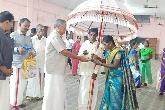 Sri.K.Kannan of the RSS in a separate event of Hindu Temples Protection Committee honours the ‘Indra’ couple standing with the white royal umbrella.