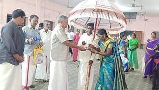 Sri.K.Kannan of the RSS in a separate event of Hindu Temples Protection Committee honours the ‘Indra’ couple standing with the white royal umbrella.