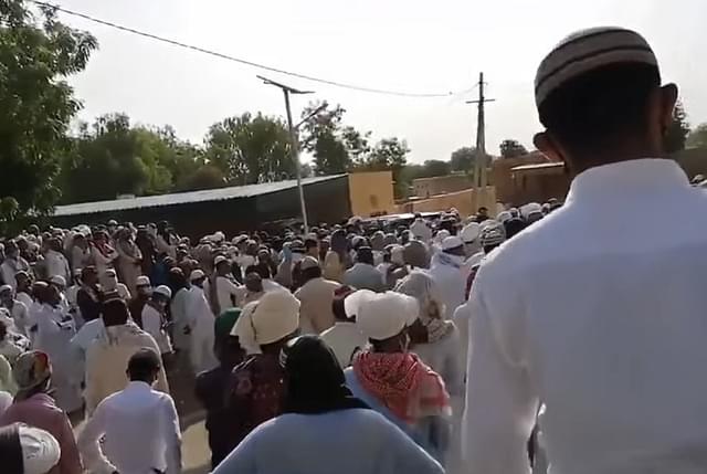 The gathering of Muslims for the funeral, despite Covid-19 protocols being in place.