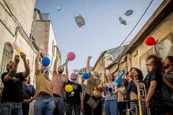 Israelis celebrating the abdication of the now-ubiquitous mask.