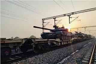 Train carries military tanks and equipment.