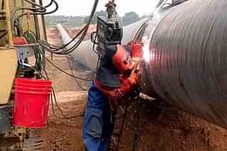 Engineers weld carbon steel pipes as part of a natural gas pipeline. (NOAH SEELAM/AFP/Getty Images)
