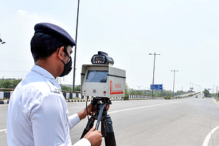 A traffic cop measuring vehicle speed on a highway using a speed gun.