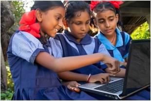 Three schooolchildren learning through a shared computer as not everyone has access to digital devices.