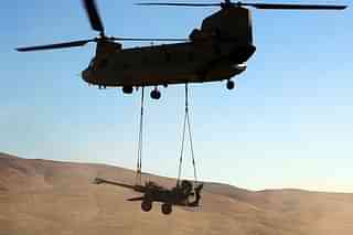 A Chinook helicopter airlifting an artillery gun. (BAE Systems/Twitter)