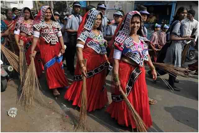 Women with broomsticks.