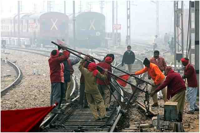 Indian Railways employees work on a railway track in New Delhi. (RAVEENDRAN/AFP/Getty Images)