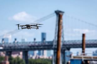 A DJI drone flying near the Brooklyn Bridge