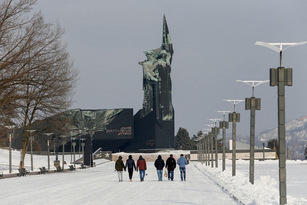 People walk towards a monument to the Liberators of Donbass in the rebel-held city of Donetsk