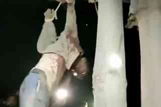 Still from a video showing the man being hanged from a tree.