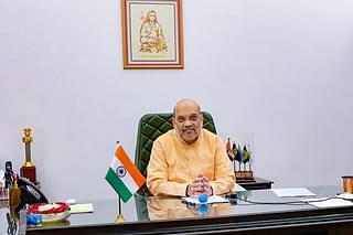 Amit Shah in his office with an image of Adi Shankaracharya, propounder of Advait Vedant, overlooking him