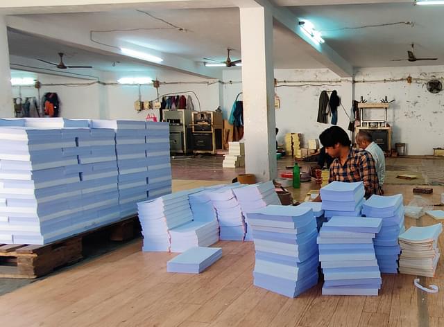 Workers applying glue manually. (Prakhar Gupta/Swarajya)