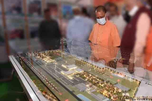 Uttar Pradesh CM Yogi Adityanath looking at a model of Noida airport (@AmanKayamHai_/Twitter)