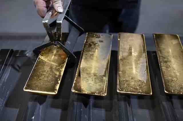 A worker removes gold ingots from moulds in Kasimov, Russia. | Source: Bloomberg 